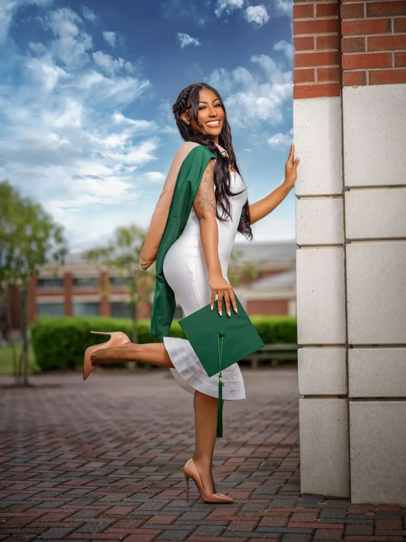 campus graduation portrait green cap gown outdoor by Motiontography