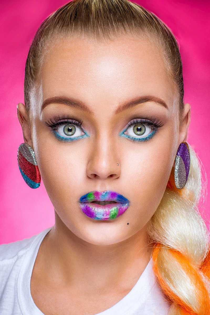 Colorful makeup beauty headshot on pink backdrop by Motiontography