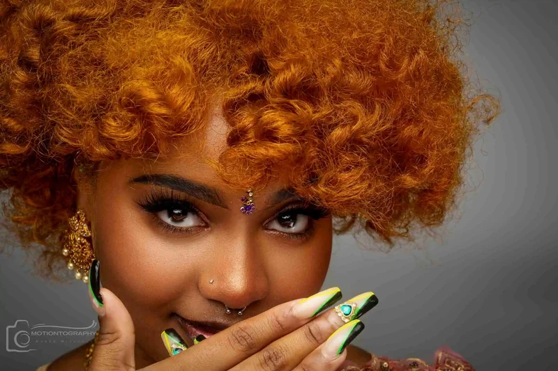 Creative beauty headshot with orange curly hair and vibrant nails by Motiontography
