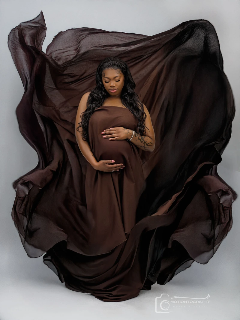 pregnant woman in brown flowing gown maternity portrait by Motiontography
