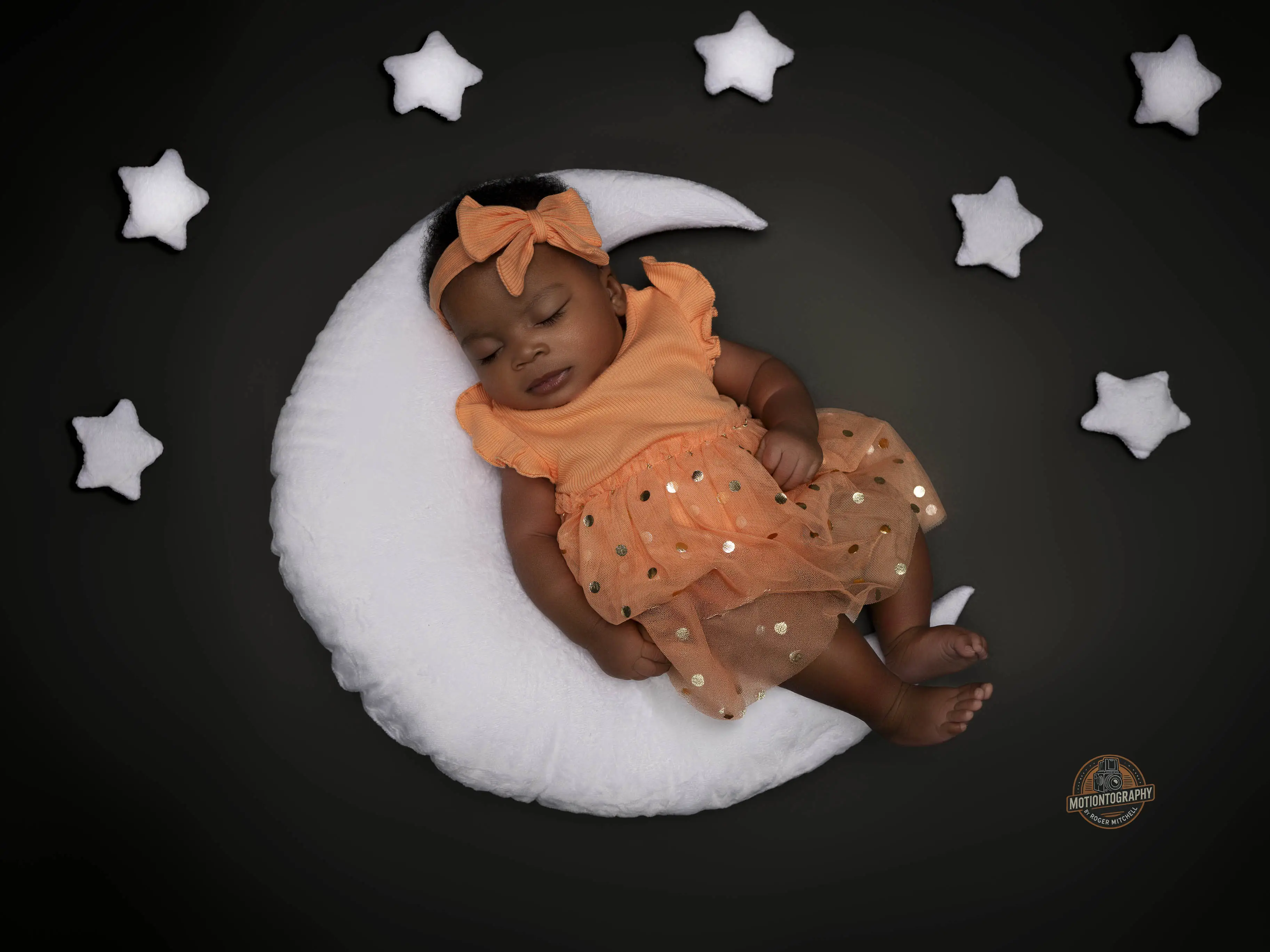 Adorable newborn baby, who appears to be a Black infant girl, sleeping on a moon prop with stars, Suffolk VA newborn photographer for Hampton Roads